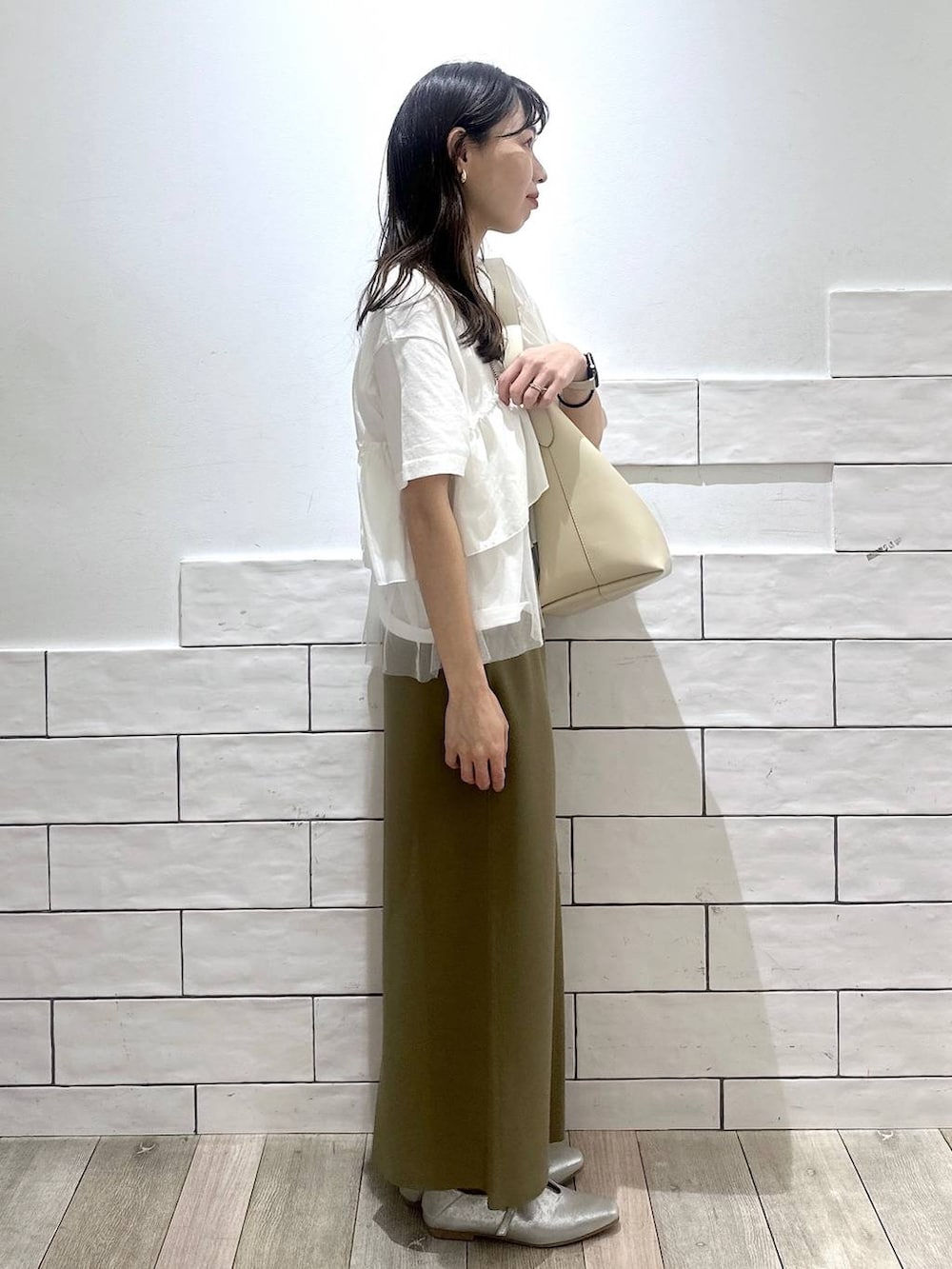 ホワイト系のトートバッグ、ホワイト系のTシャツ/カットソー、シルバー系のネックレスを着用したレディースの春コーディネートの2枚目の写真