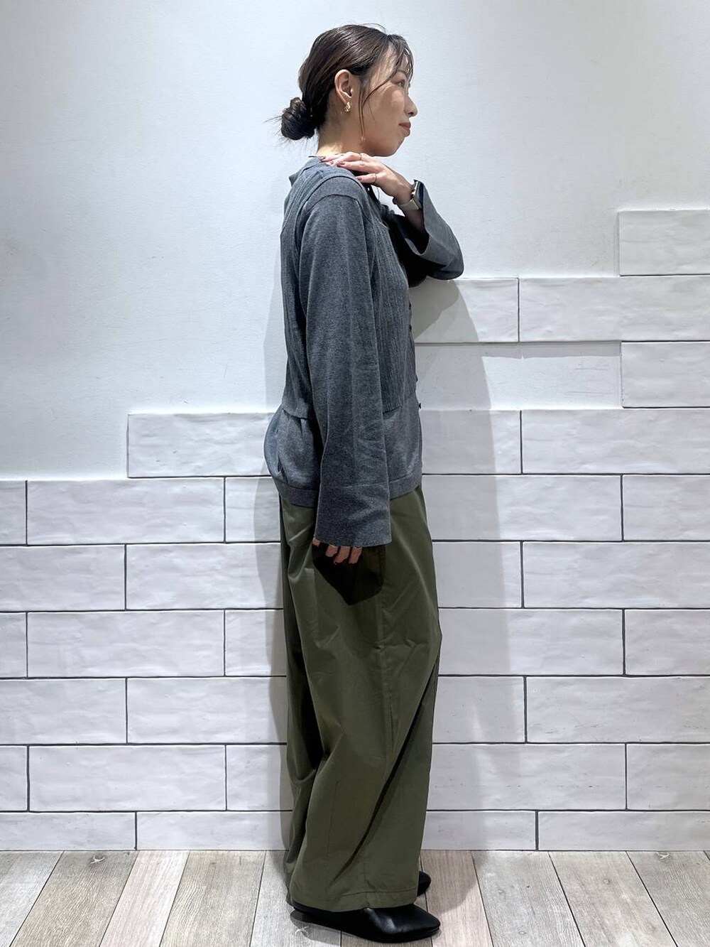 グレー系のニット/セーター、ブラック系のその他シューズ、グリーン系のその他パンツを着用したレディースの夏コーディネートの2枚目の写真