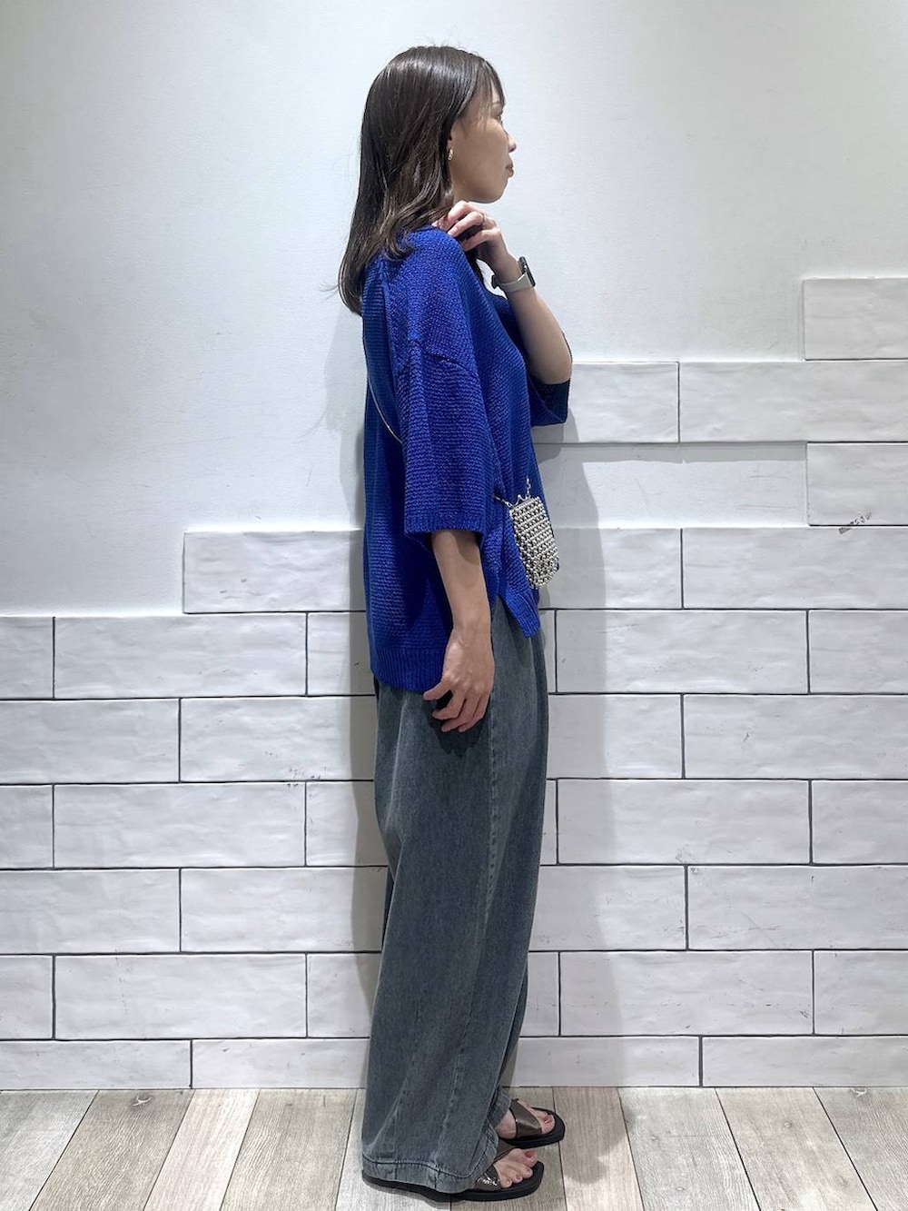 ブルー系のデニムパンツ、その他のサンダル、ブルー系のニット/セーターを着用したレディースの夏コーディネートの2枚目の写真