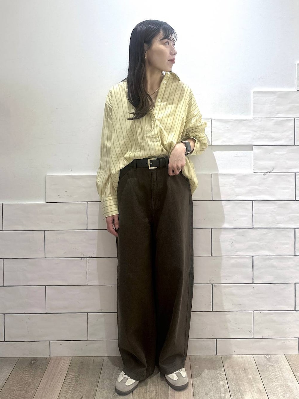 グリーン系のその他パンツ、イエロー系のシャツ/ブラウス、ブラック系のベルトを着用したレディースの冬コーディネートの2枚目の写真