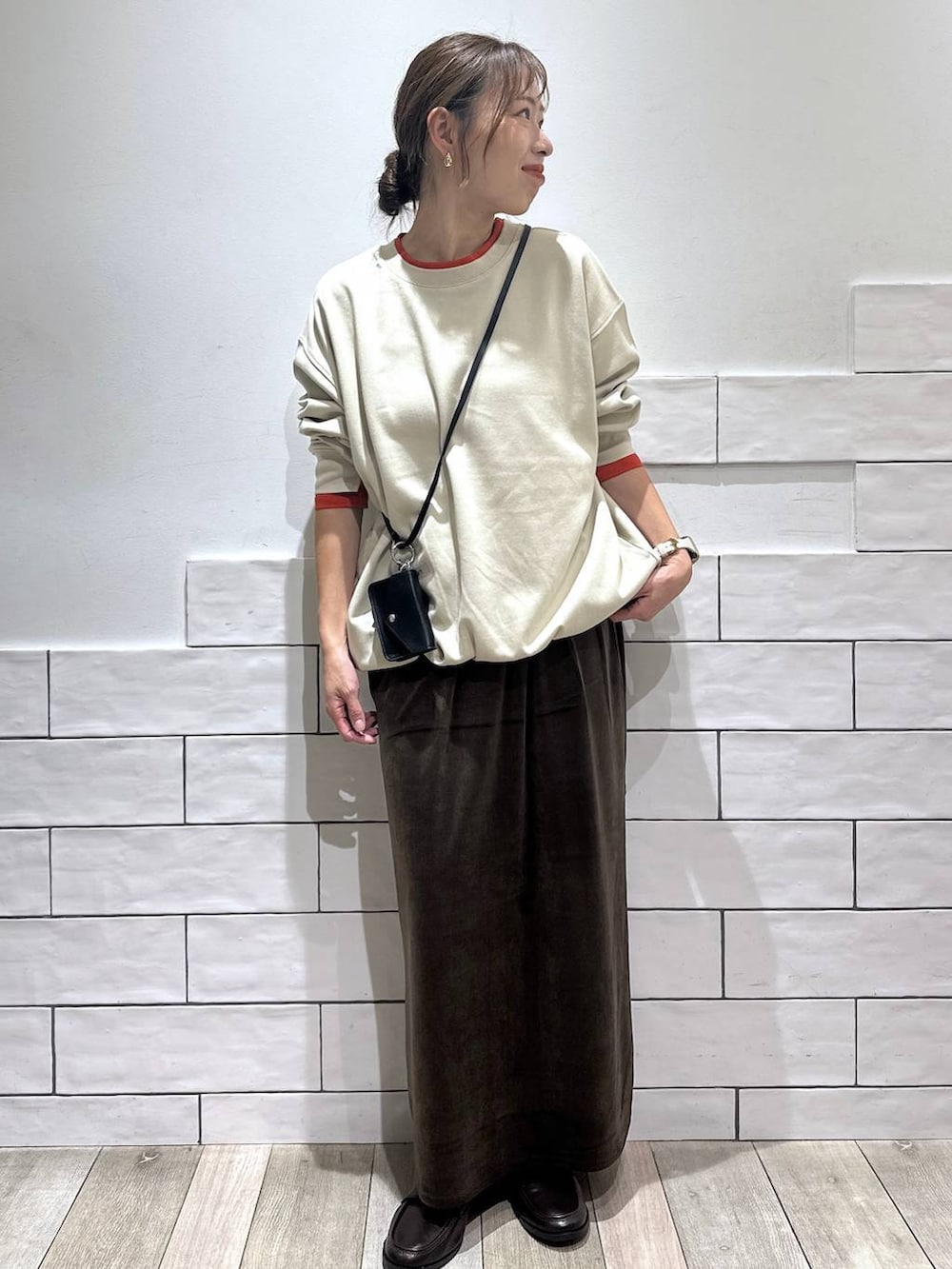 ブラウン系のローファー、ベージュ系のTシャツ/カットソー、ブラウン系のスカートを着用したレディースの秋コーディネートの3枚目の写真