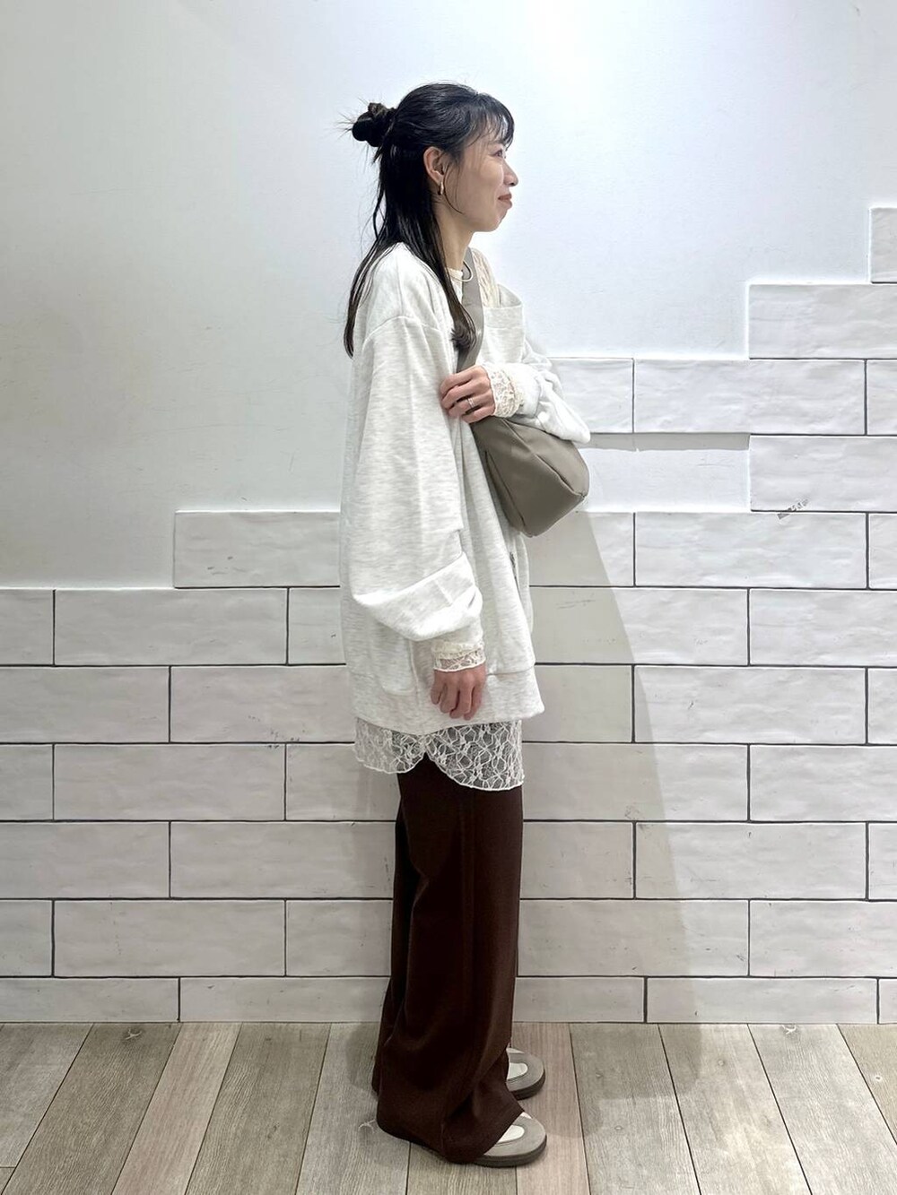 ブラウン系のその他パンツ、グレー系のTシャツ/カットソー、シルバー系のショルダーバッグを着用したレディースの冬コーディネートの2枚目の写真