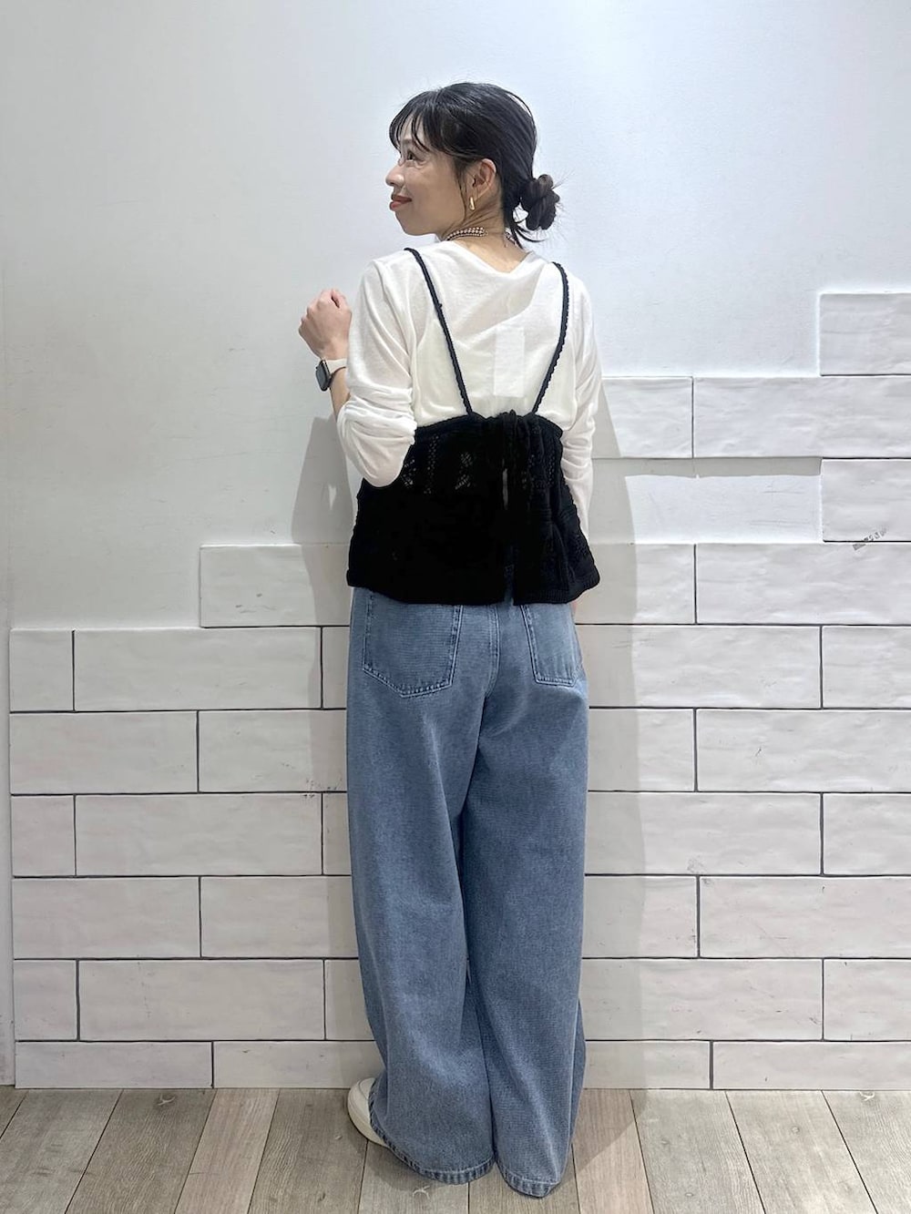 ホワイト系のTシャツ/カットソー、ブルー系のデニムパンツ、ブラック系のキャミソールを着用したレディースの冬コーディネートの4枚目の写真