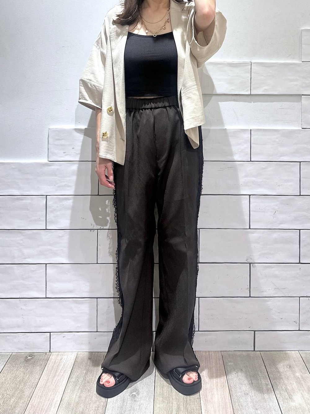 ブラウン系のその他パンツ、ベージュ系のテーラードジャケット、ブラック系のサンダルを着用したレディースの夏コーディネートの5枚目の写真
