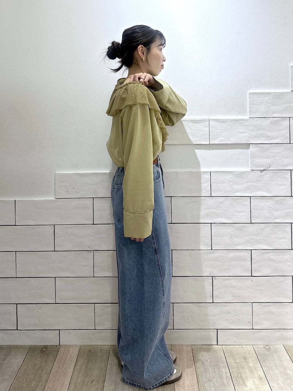 ブルー系のデニムパンツ、ブラウン系のベルトを着用したレディースの冬コーディネートの2枚目の写真