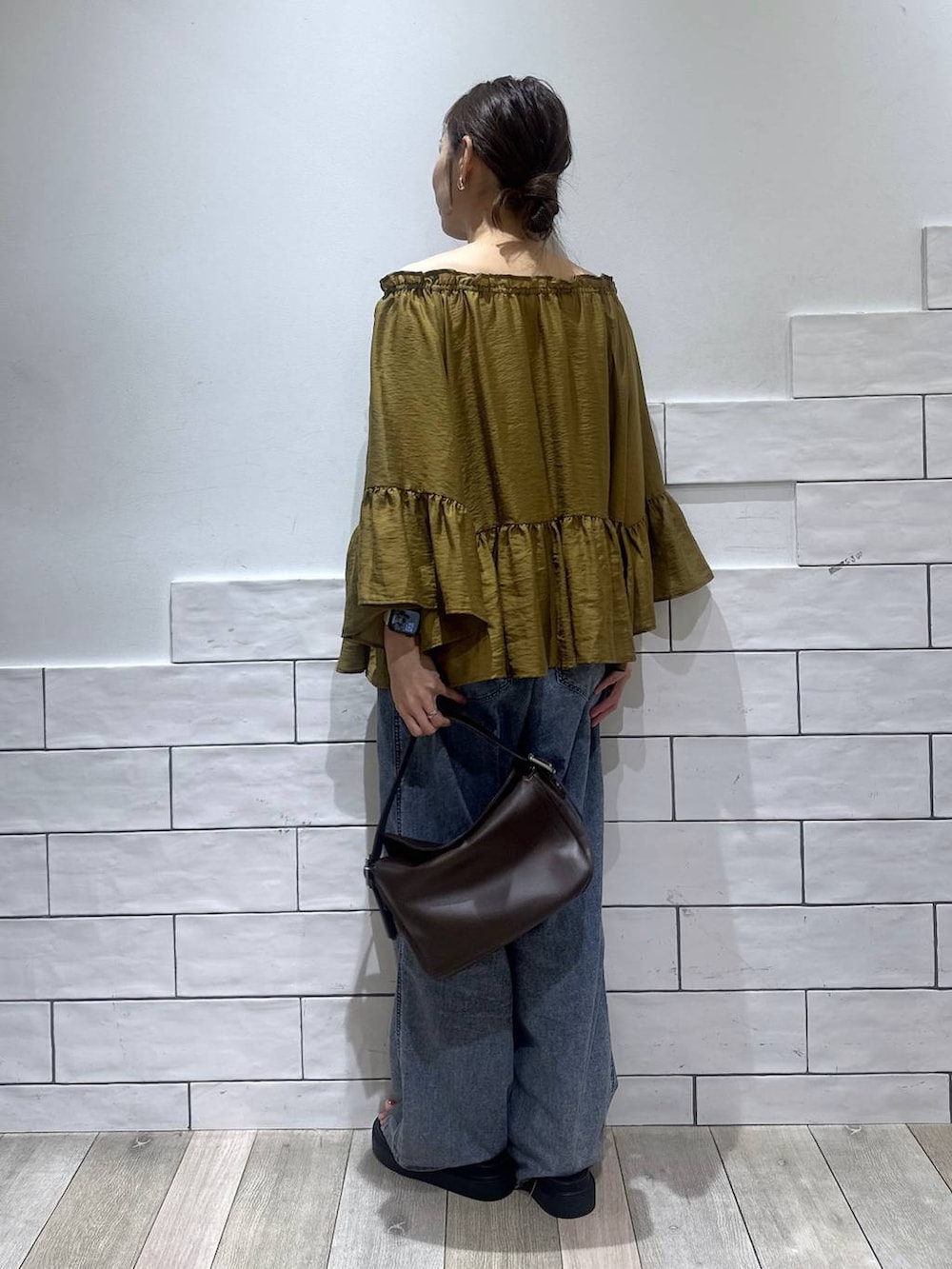 ブルー系のデニムパンツ、ブラック系のサンダル、ブラウン系のショルダーバッグを着用したレディースの夏コーディネートの4枚目の写真