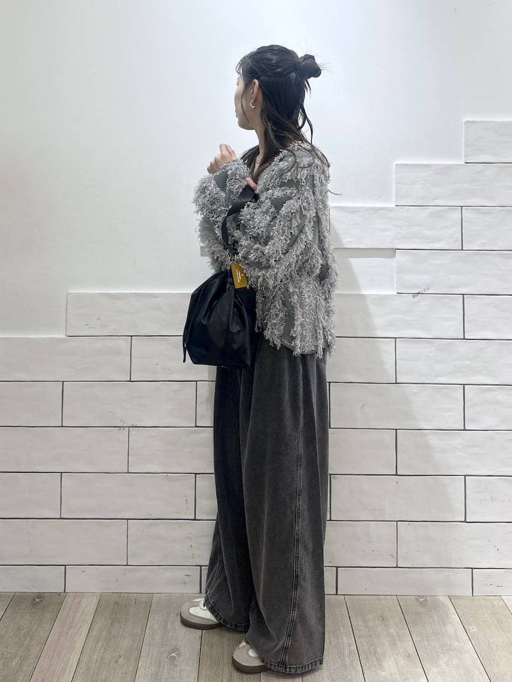 ブラック系のショルダーバッグ、グレー系のデニムパンツ、グリーン系のカーディガン/ボレロを着用したレディースの冬コーディネートの5枚目の写真