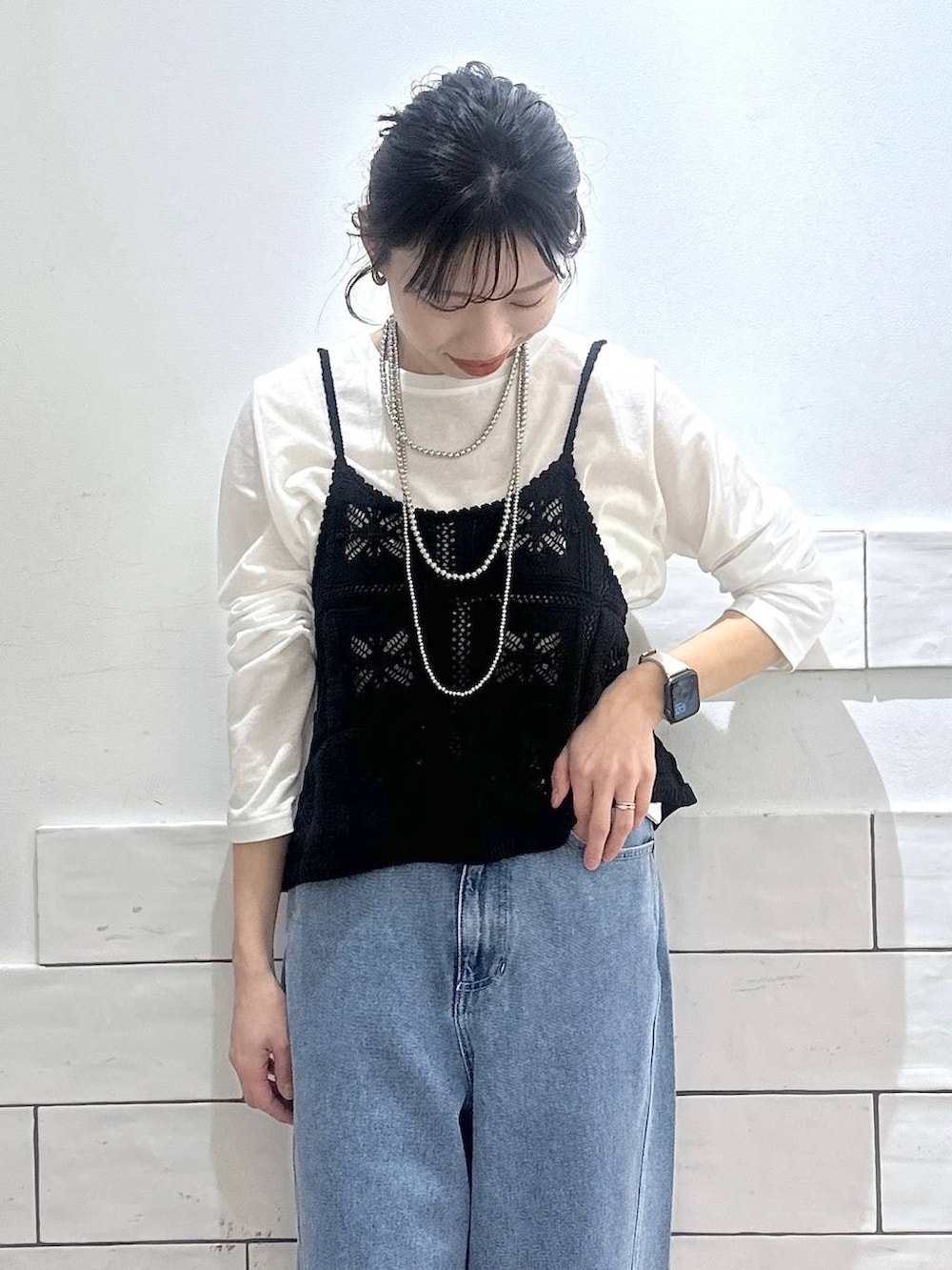 ホワイト系のTシャツ/カットソー、ブルー系のデニムパンツ、ブラック系のキャミソールを着用したレディースの冬コーディネートの2枚目の写真