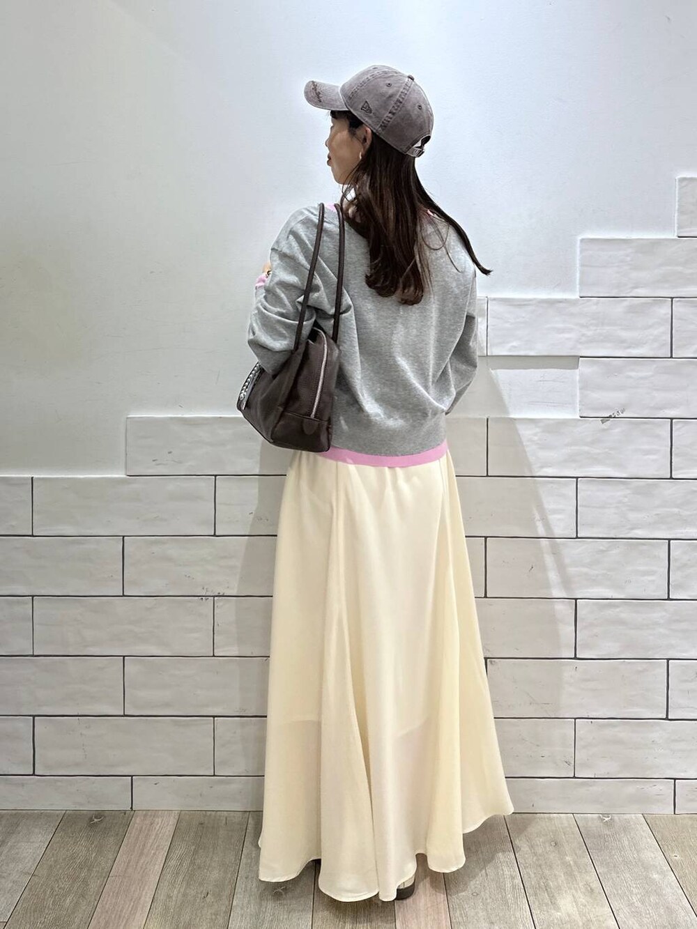 ブラウン系のボストンバッグ、ホワイト系のスカート、グレー系のカーディガン/ボレロを着用したレディースの冬コーディネートの3枚目の写真