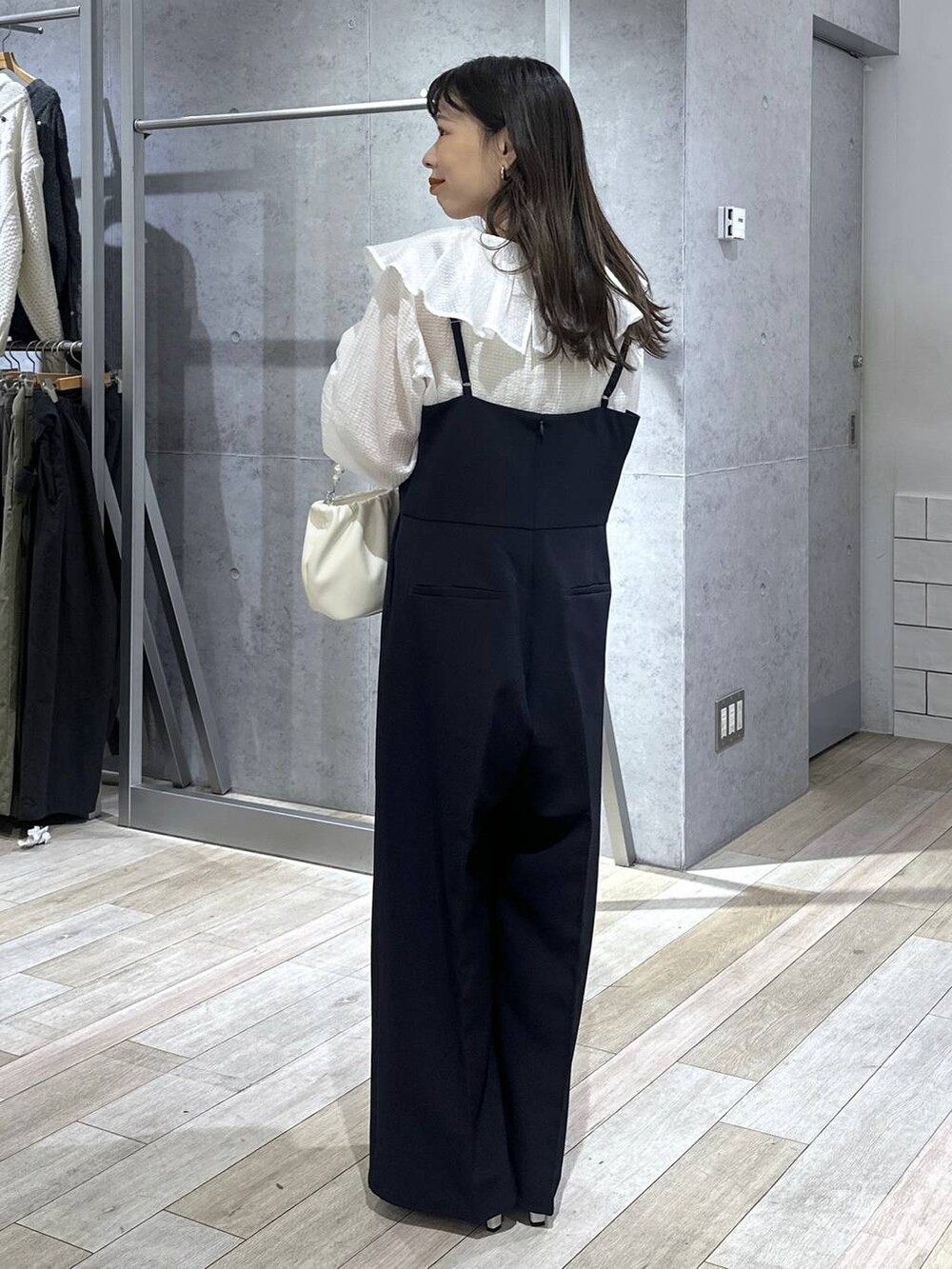 ブルー系のサロペット/オーバーオール、ホワイト系のシャツ/ブラウス、ホワイト系のショルダーバッグを着用したレディースの冬コーディネートの2枚目の写真