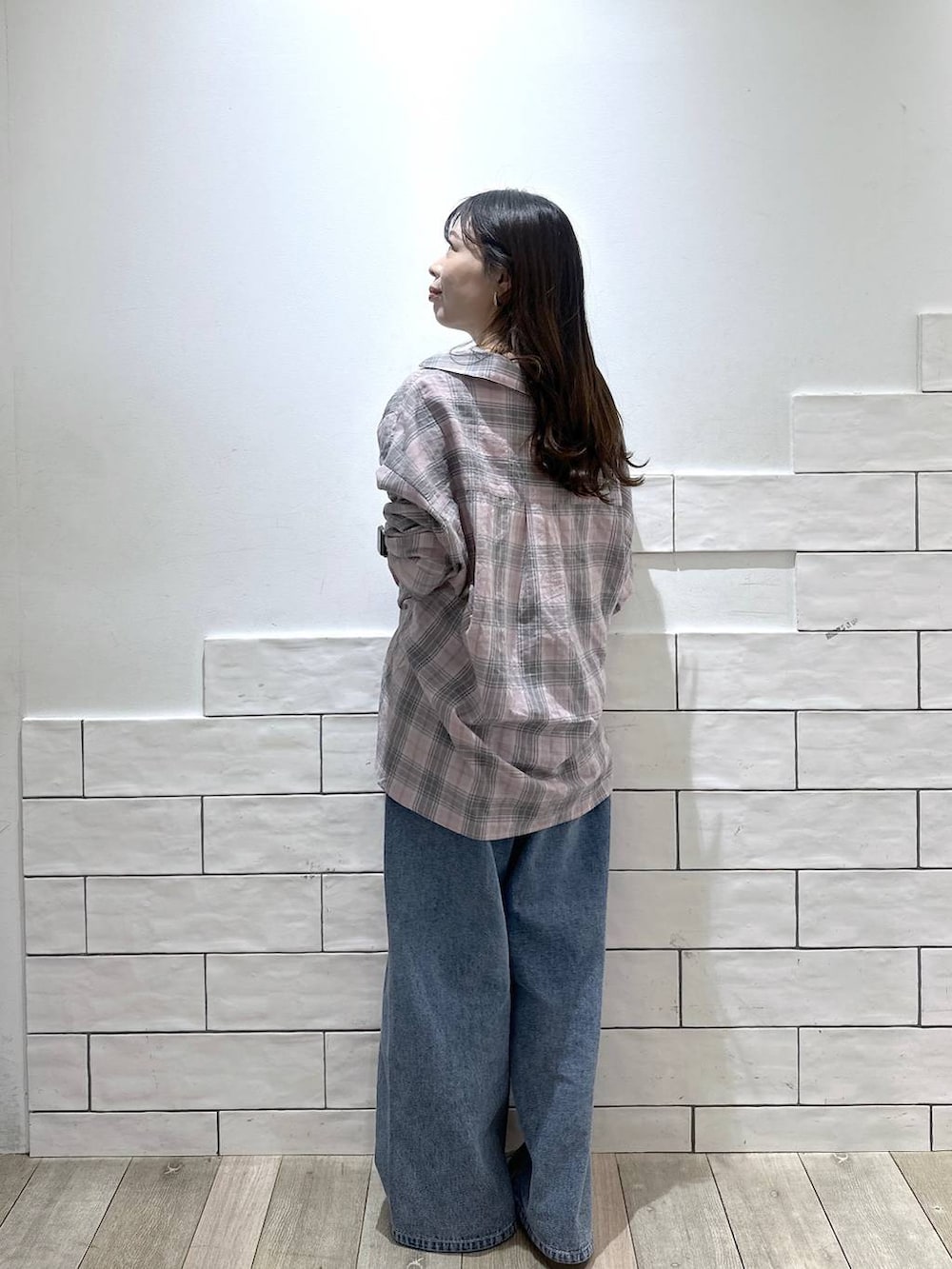 ブルー系のデニムパンツ、ピンク系のシャツ/ブラウス、ホワイト系のニットキャップ/ビーニーを着用したレディースの春コーディネートの3枚目の写真