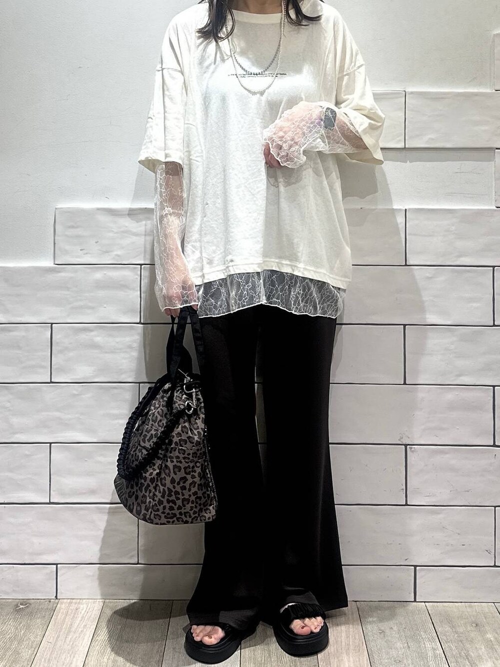 その他のショルダーバッグ、ブラック系のサンダル、ホワイト系のTシャツ/カットソーを着用したレディースの夏コーディネートの2枚目の写真