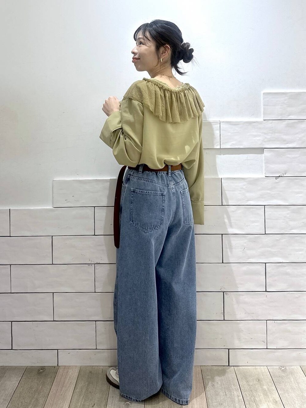 ブルー系のデニムパンツ、ブラウン系のベルトを着用したレディースの冬コーディネートの4枚目の写真