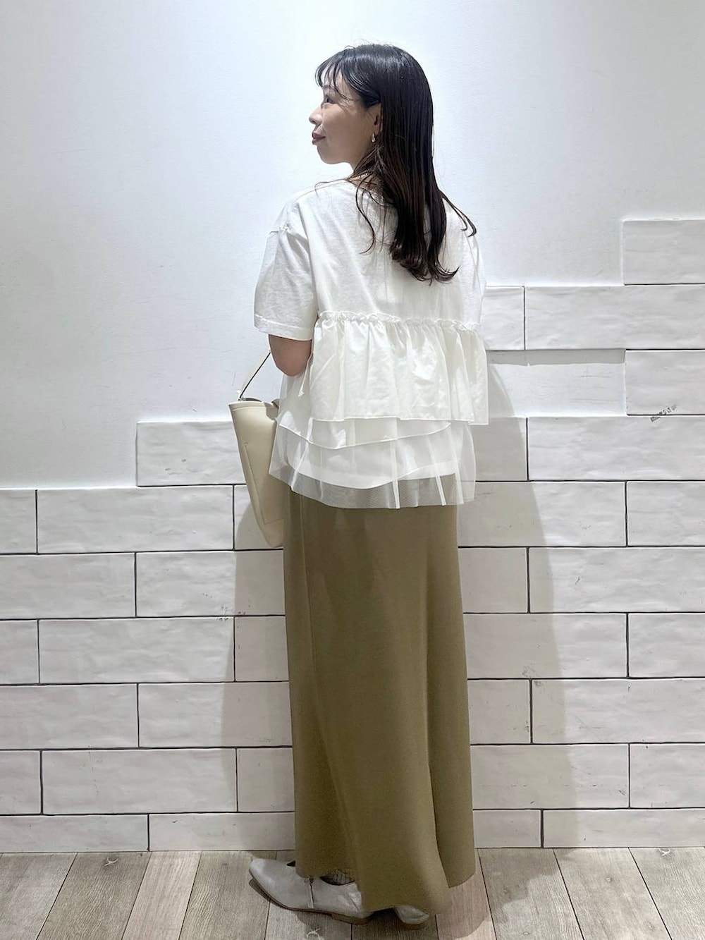 ホワイト系のトートバッグ、ホワイト系のTシャツ/カットソー、シルバー系のネックレスを着用したレディースの春コーディネートの3枚目の写真