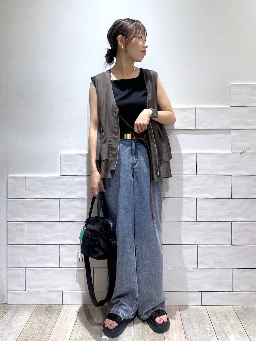 ブラック系のトートバッグ、ブルー系のデニムパンツ、ブラック系のサンダルを着用したレディースの夏コーディネートの4枚目の写真