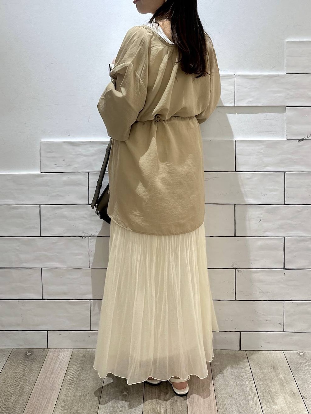 ブラウン系のショルダーバッグ、ホワイト系のスカート、ブラウン系のシャツ/ブラウスを着用したレディースの春コーディネートの3枚目の写真