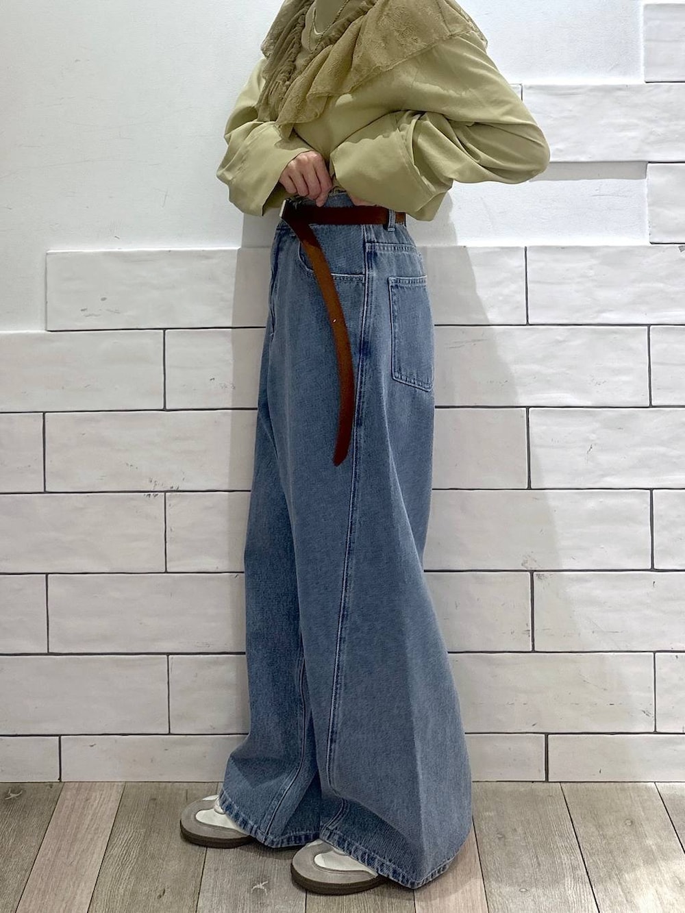 ブルー系のデニムパンツ、ブラウン系のベルトを着用したレディースの冬コーディネートの5枚目の写真