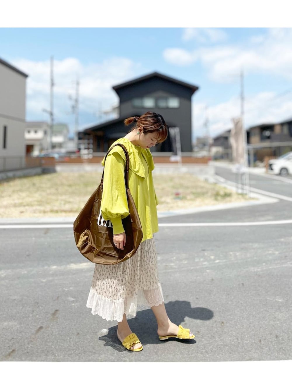 イエロー系のTシャツ/カットソー、ブラウン系のエコバッグ/サブバッグ、ベージュ系のスカートを着用したレディースの春コーディネートの2枚目の写真