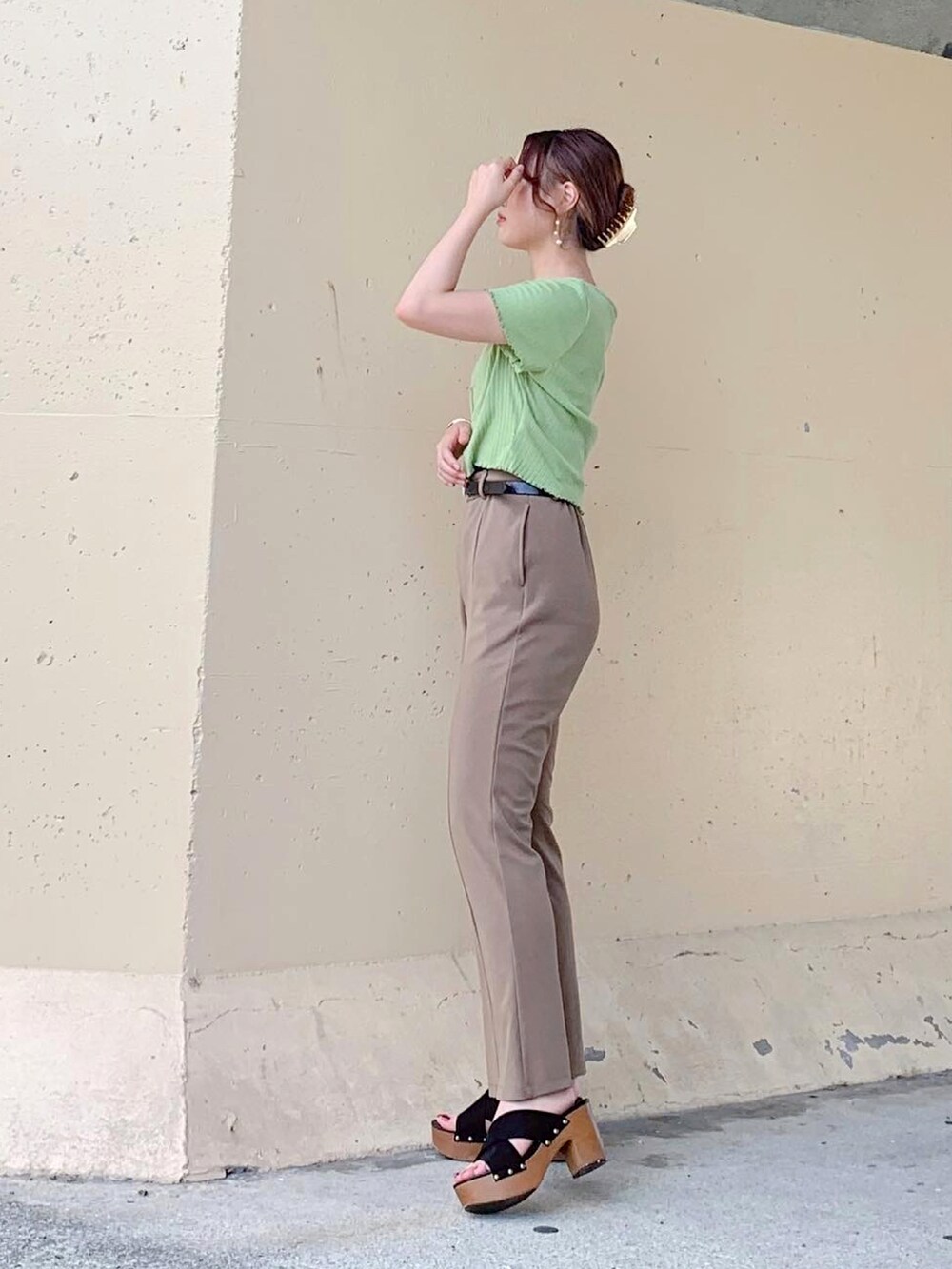 グリーン系のトップス、ベージュ系のその他パンツ、ブラック系のパンツを着用したレディースの夏コーディネートの3枚目の写真