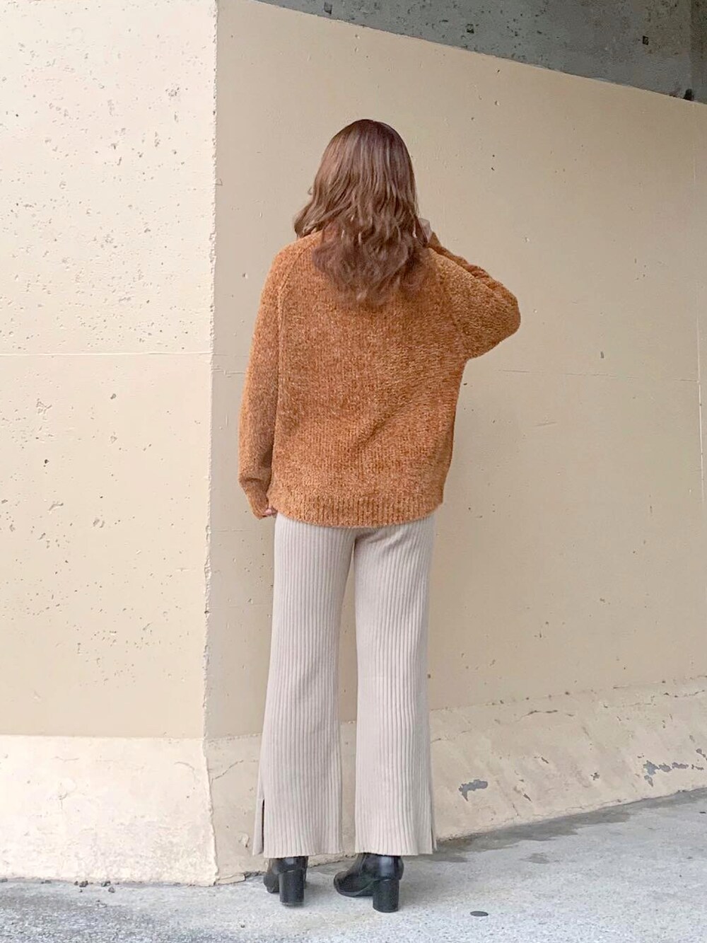 イエロー系のニット/セーター、イエロー系のトップス、ブラウン系のチェスターコートを着用したレディースの冬コーディネートの5枚目の写真