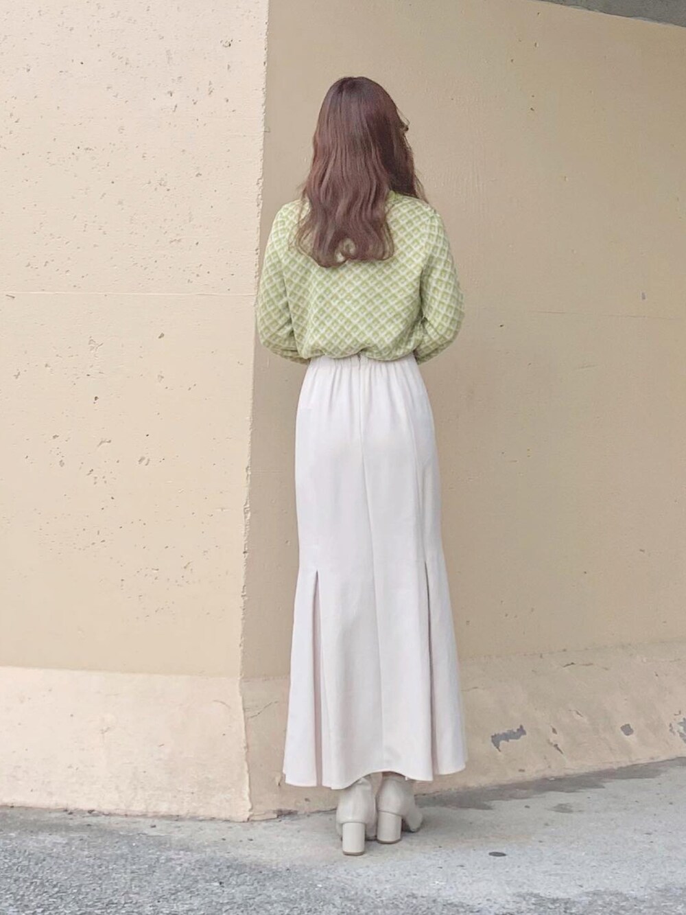 グリーン系のトップス、ホワイト系のスカート、ホワイト系のTシャツ/カットソーを着用したレディースの秋コーディネートの4枚目の写真