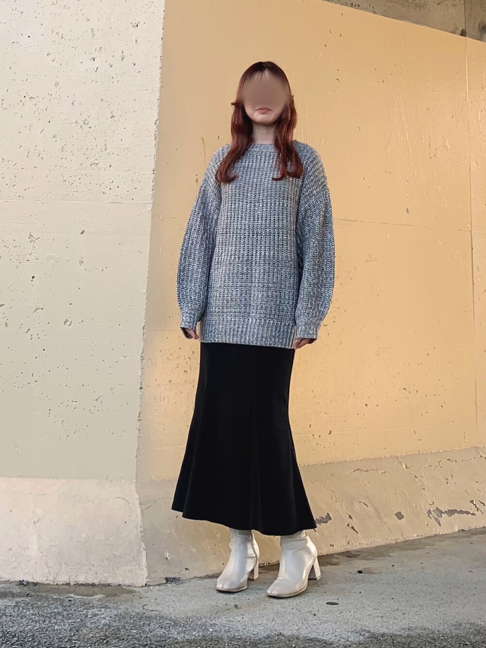 グレー系のニット/セーター、ブラック系のスカート、ブラック系のスカートを着用したレディースの春コーディネートの2枚目の写真
