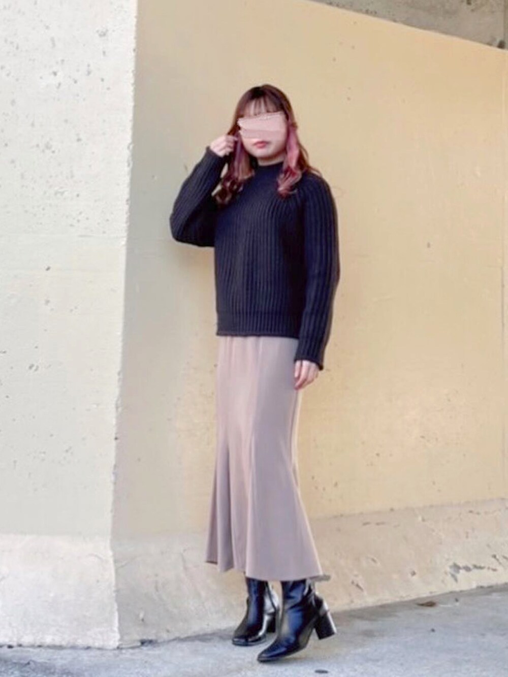 ブラック系のトップス、ブラック系のニット/セーター、ベージュ系のスカートを着用したレディースの春コーディネートの3枚目の写真