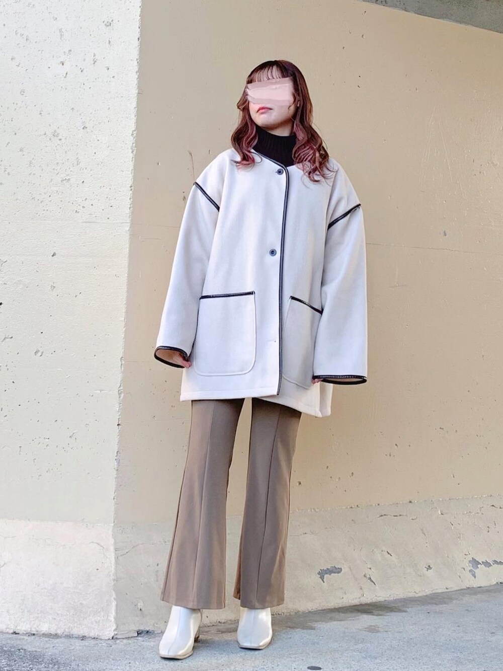 ベージュ系のノーカラーコート、ホワイト系のその他アウター、ベージュ系のその他パンツを着用したレディースの春コーディネートの2枚目の写真