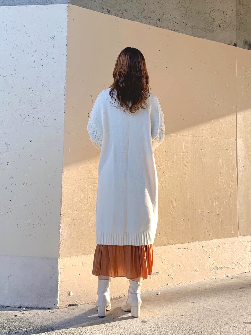 ホワイト系のニット/セーター、ホワイト系のワンピース、ブラウン系のスカートを着用したレディースの冬コーディネートの5枚目の写真