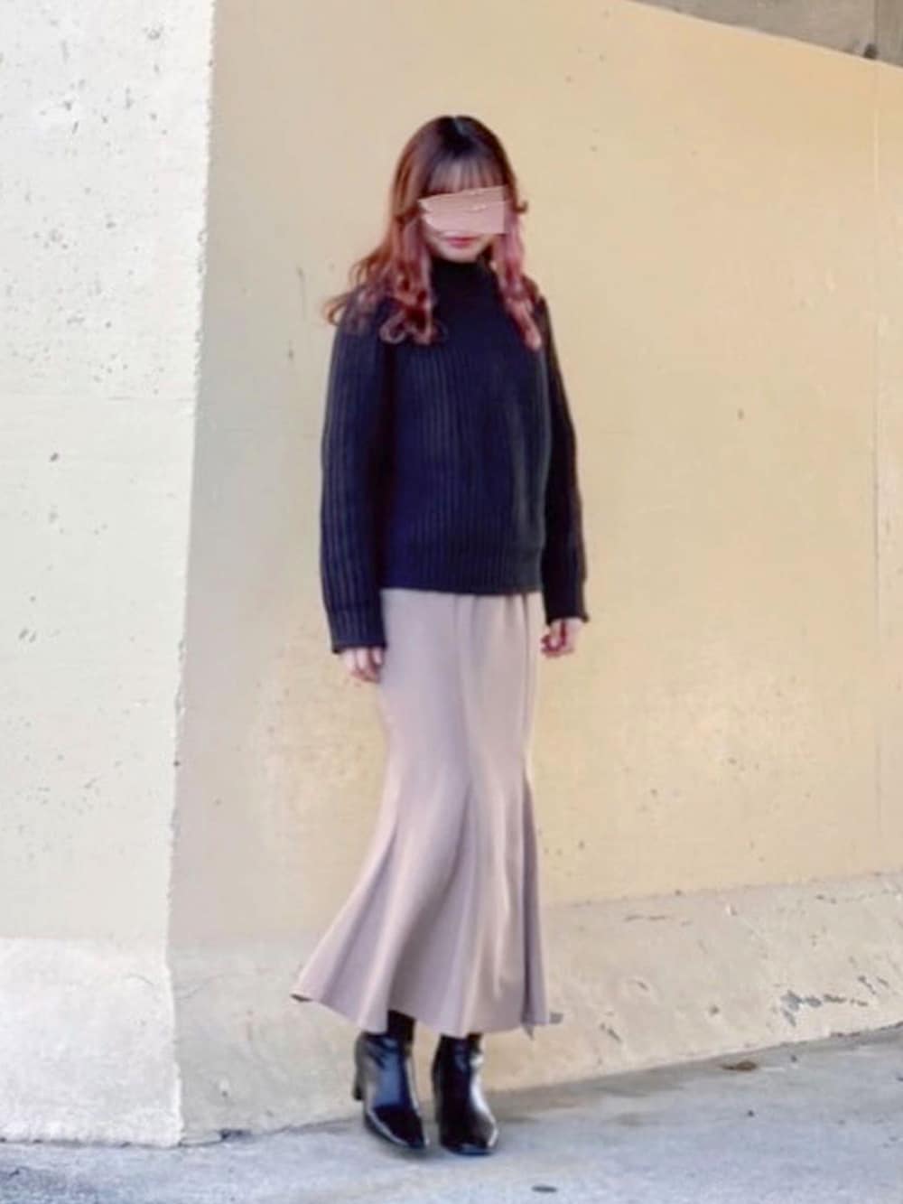 ブラック系のトップス、ブラック系のニット/セーター、ベージュ系のスカートを着用したレディースの春コーディネートの2枚目の写真