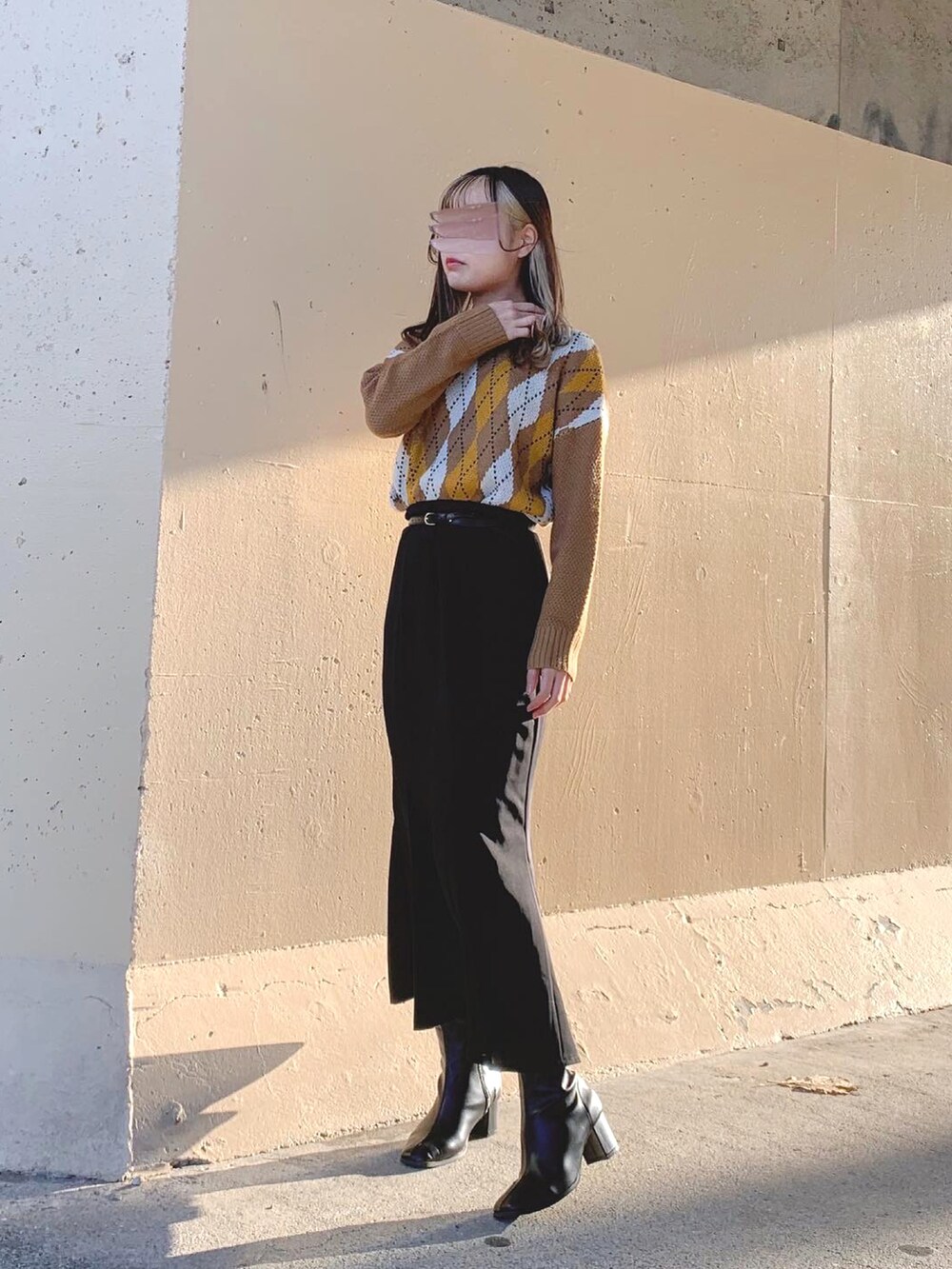 ブラウン系のトップス、ベージュ系のニット/セーター、ブラック系のスカートを着用したレディースの冬コーディネートの3枚目の写真