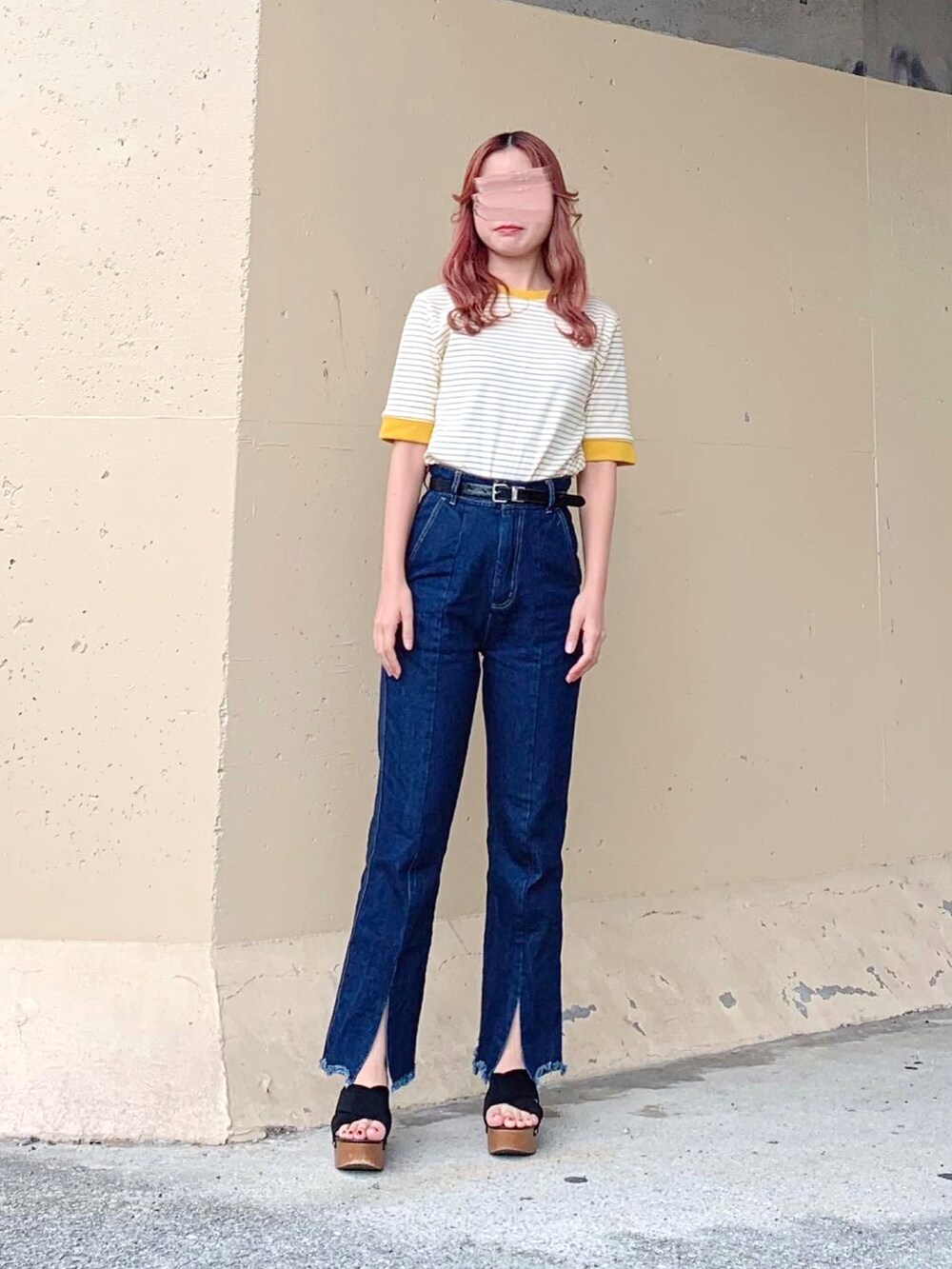 イエロー系のトップス、ブルー系のデニムパンツ、ブラック系のデニムパンツを着用したレディースの秋コーディネートの4枚目の写真