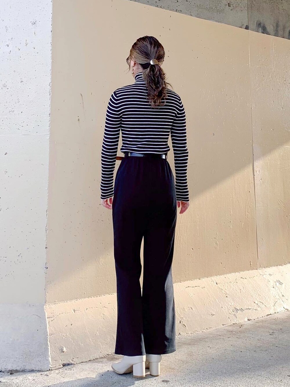 ブラック系のTシャツ/カットソー、ブラック系のトップス、ブラック系のスラックスを着用したレディースの秋コーディネートの4枚目の写真