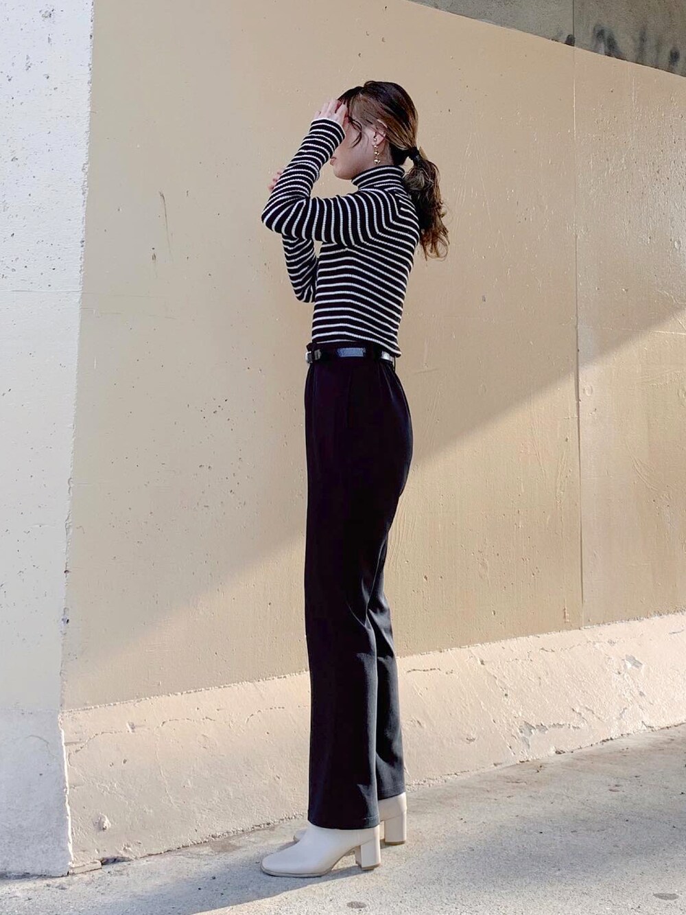 ブラック系のTシャツ/カットソー、ブラック系のトップス、ブラック系のスラックスを着用したレディースの秋コーディネートの3枚目の写真