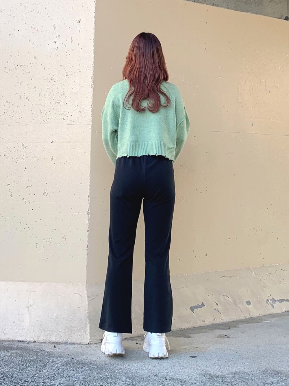 イエロー系のニット/セーター、グリーン系のニット/セーター、ブラック系のスラックスを着用したレディースの春コーディネートの3枚目の写真