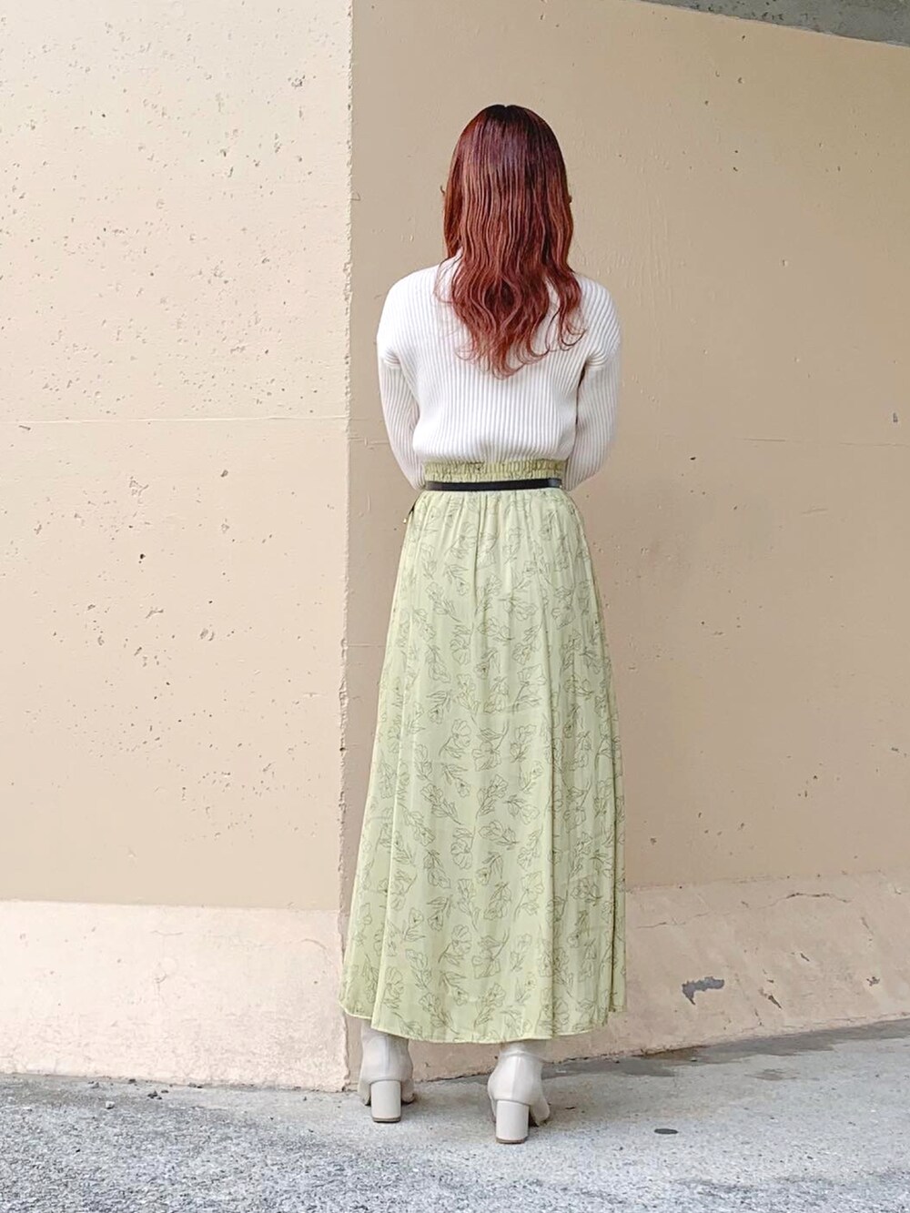 ホワイト系のニット/セーター、イエロー系のスカート、イエロー系のスカートを着用したレディースの春コーディネートの3枚目の写真