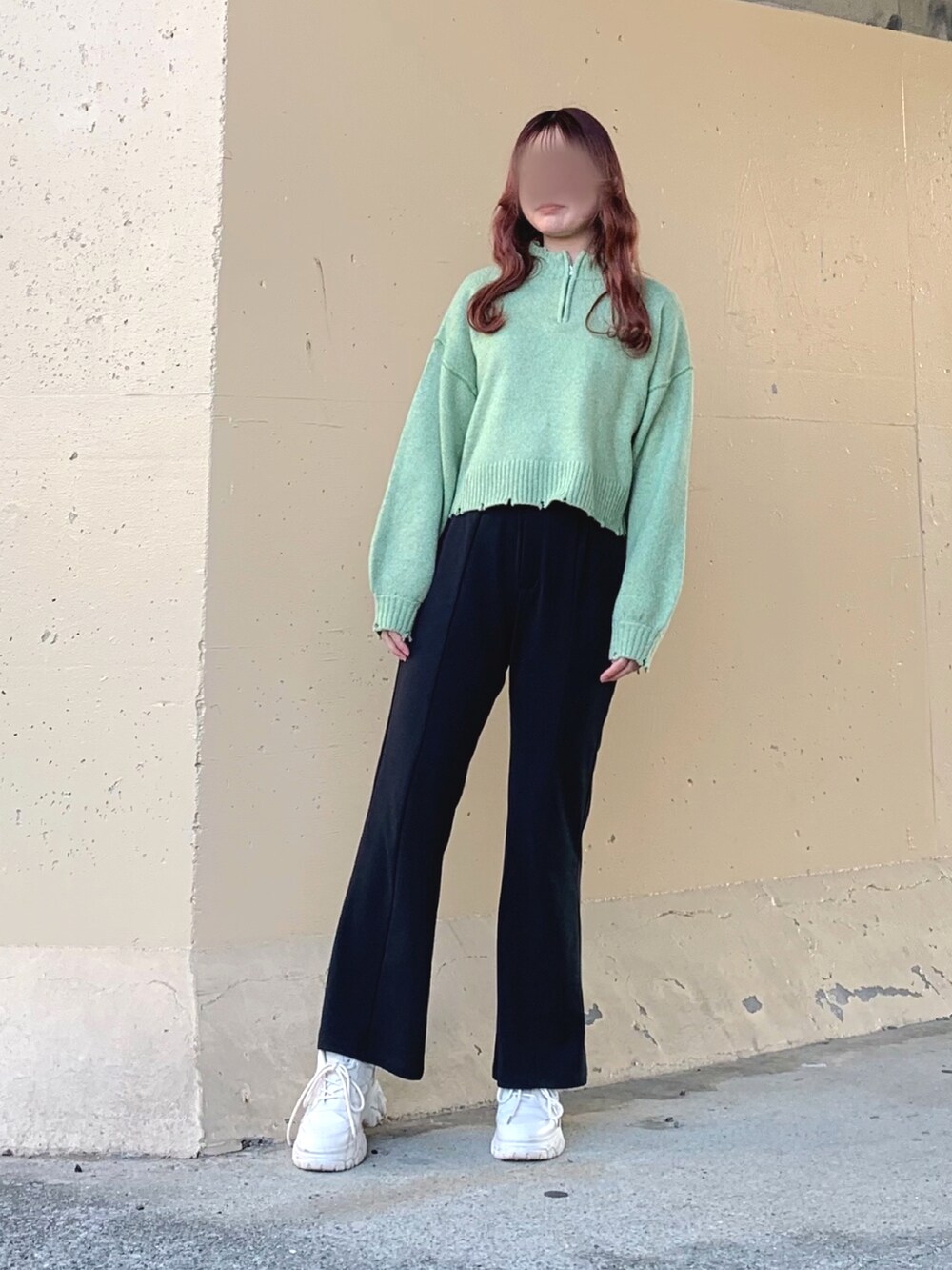 イエロー系のニット/セーター、グリーン系のニット/セーター、ブラック系のスラックスを着用したレディースの春コーディネートの2枚目の写真