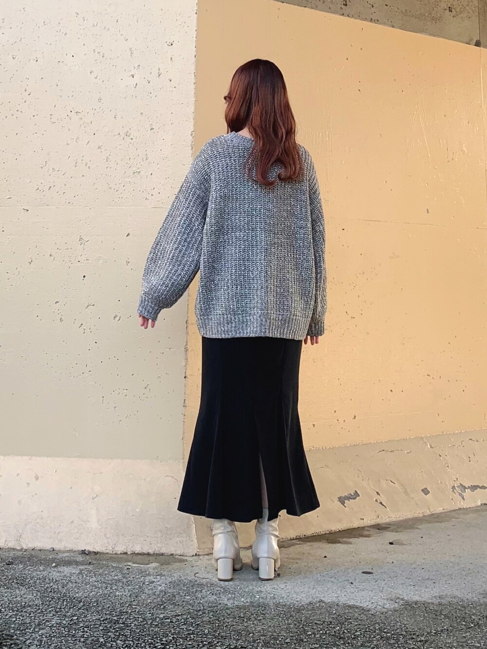 グレー系のニット/セーター、ブラック系のスカート、ブラック系のスカートを着用したレディースの春コーディネートの4枚目の写真