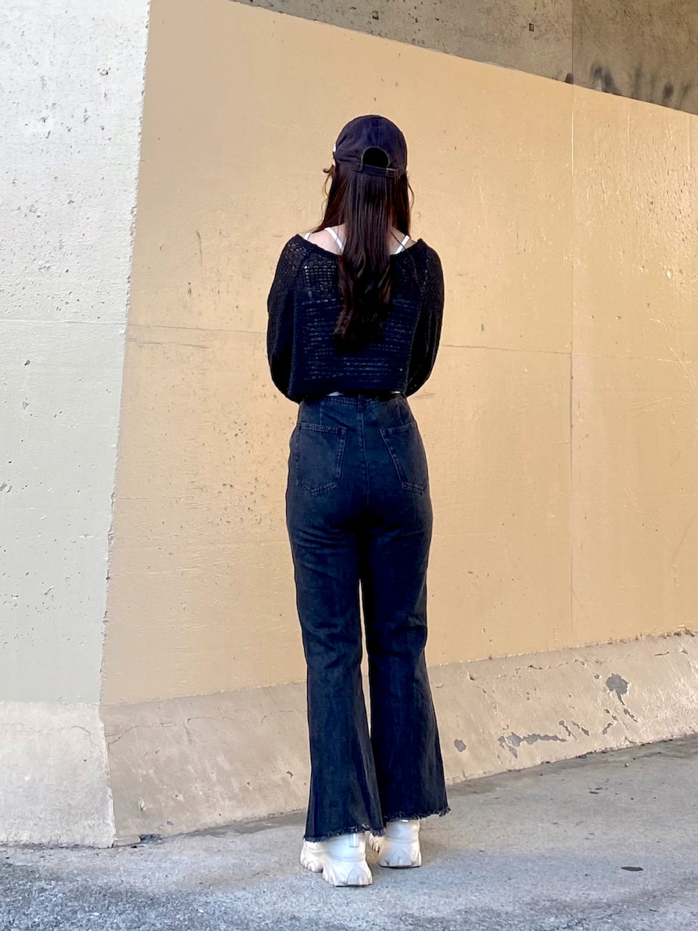 ブラック系のキャミソール、ブラック系のカーディガン/ボレロ、ブルー系のデニムパンツを着用したレディースの秋コーディネートの4枚目の写真