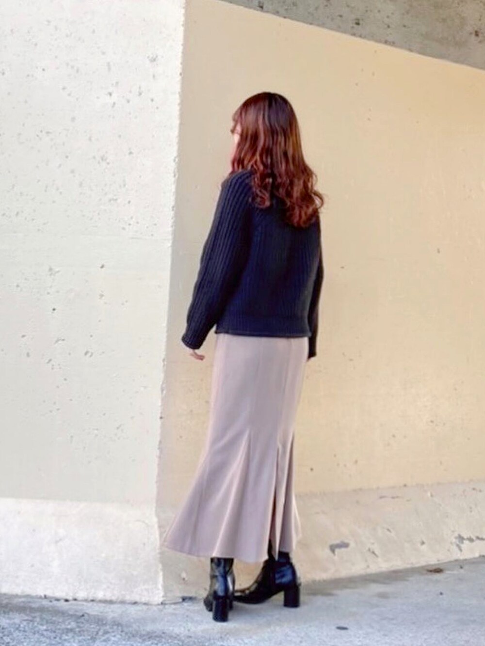 ブラック系のトップス、ブラック系のニット/セーター、ベージュ系のスカートを着用したレディースの春コーディネートの4枚目の写真