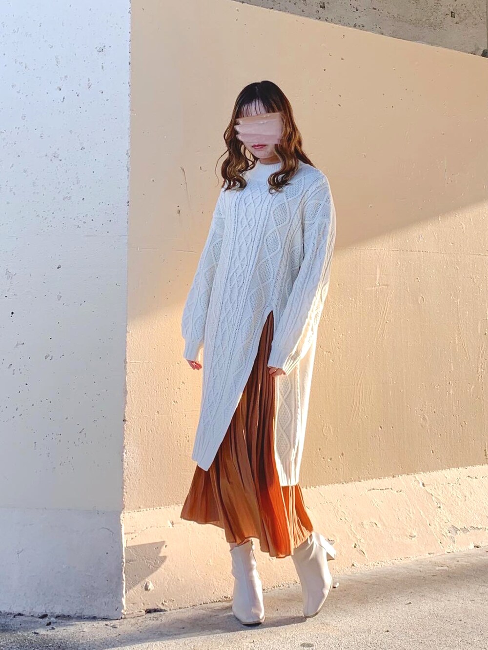 ホワイト系のニット/セーター、ホワイト系のワンピース、ブラウン系のスカートを着用したレディースの冬コーディネートの2枚目の写真