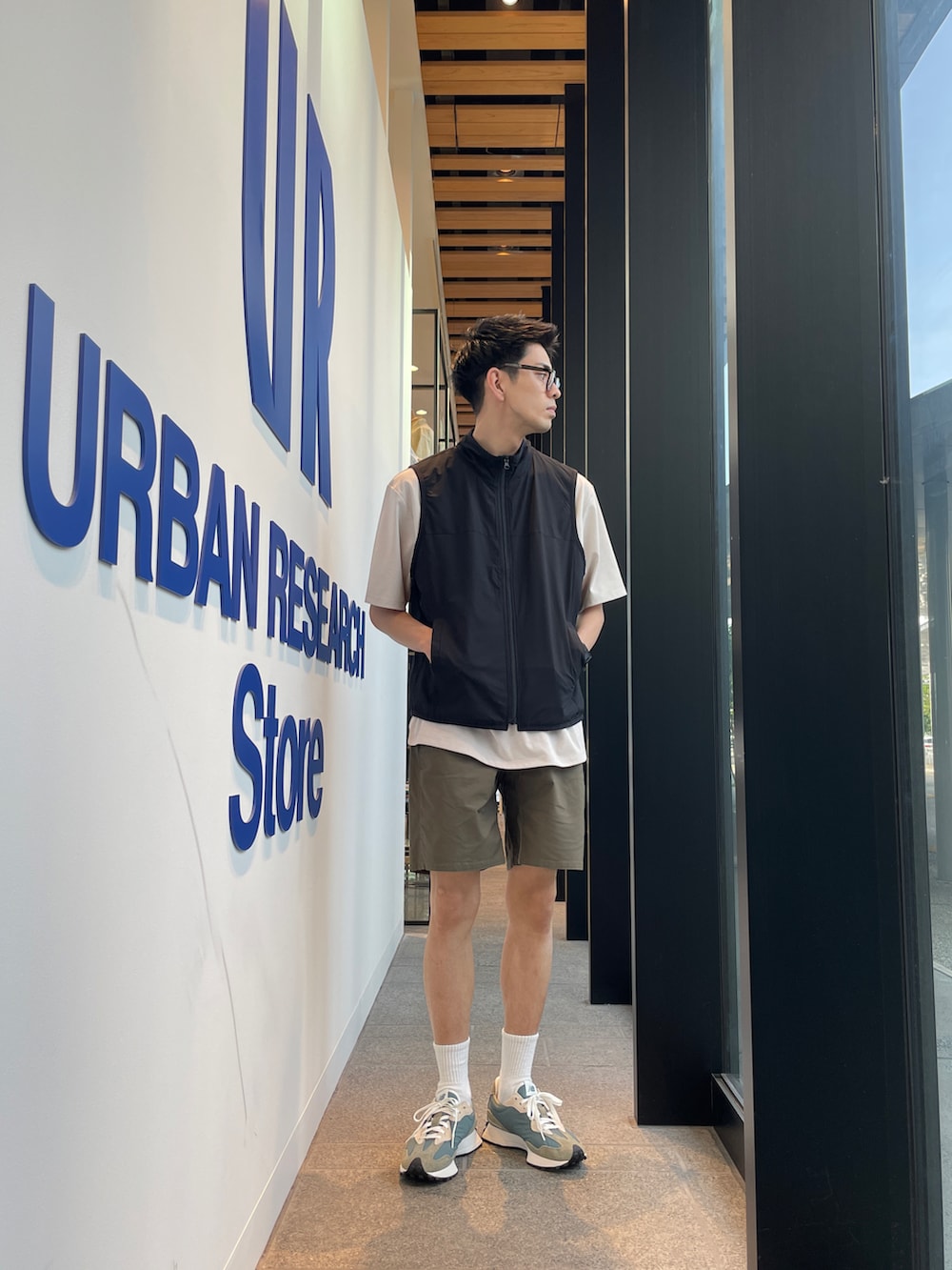 ブラック系のベスト、グリーン系のその他パンツ、グリーン系のスニーカーを着用したメンズの夏コーディネートの2枚目の写真