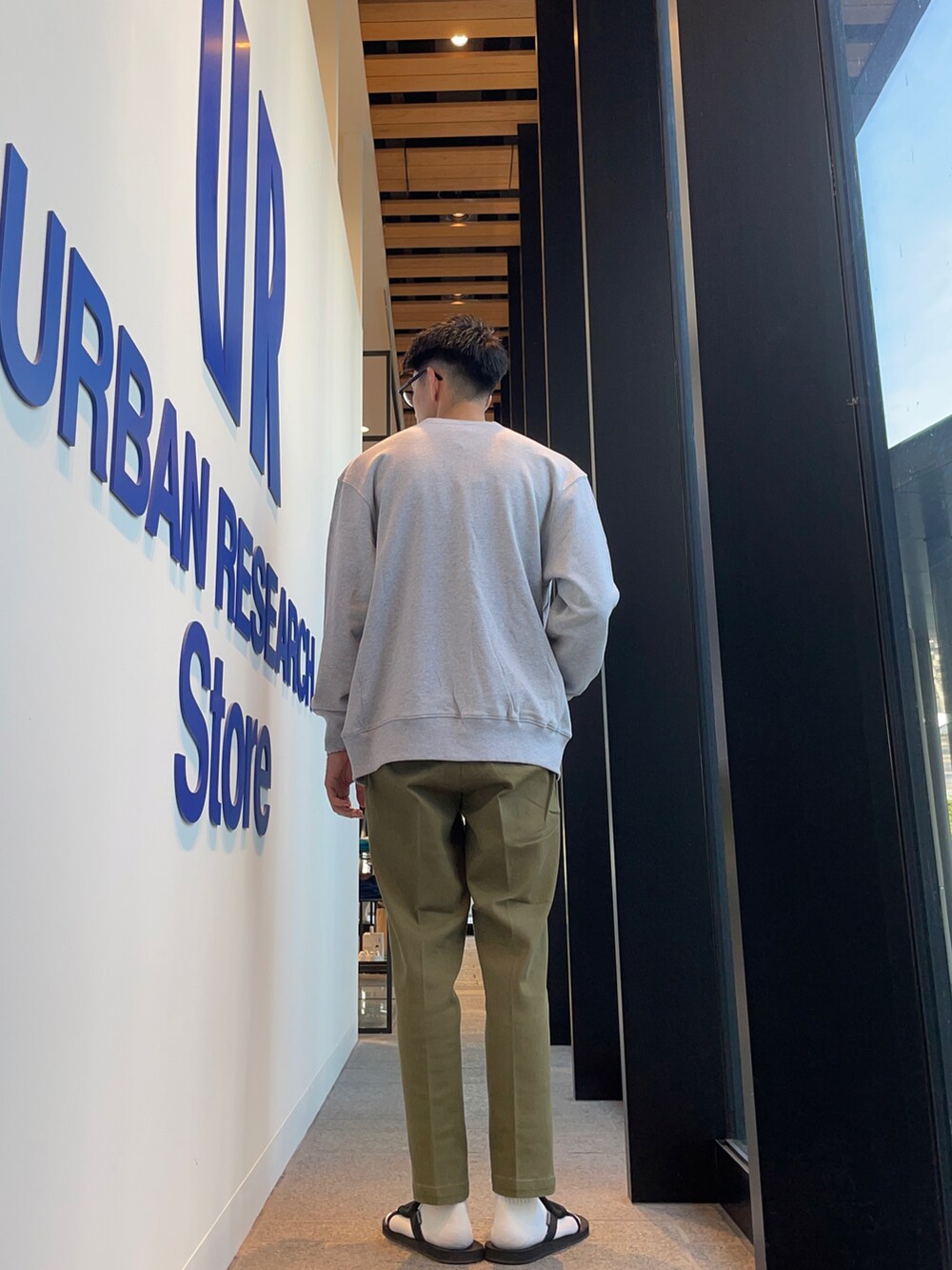 グレー系のカーディガン/ボレロ、ベージュ系のTシャツ/カットソー、グリーン系のチノパンツを着用したメンズの秋コーディネートの3枚目の写真