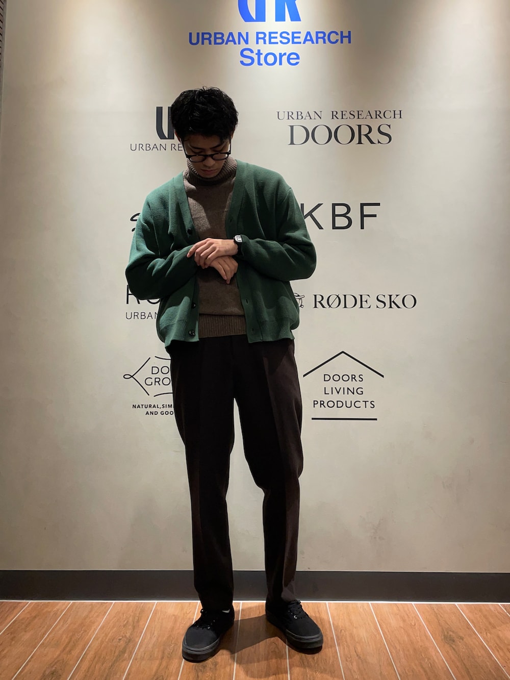 ブラウン系のニット/セーター、グリーン系のカーディガン/ボレロ、ブラウン系のその他パンツを着用したメンズの秋コーディネートの2枚目の写真