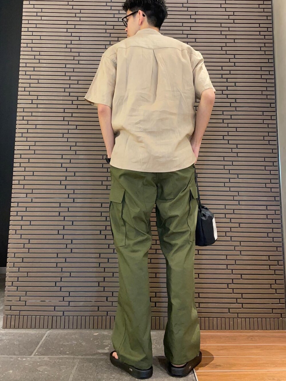 ベージュ系のシャツ/ブラウス、グリーン系のカーゴパンツ、ブラック系のサンダルを着用したメンズの夏コーディネートの3枚目の写真