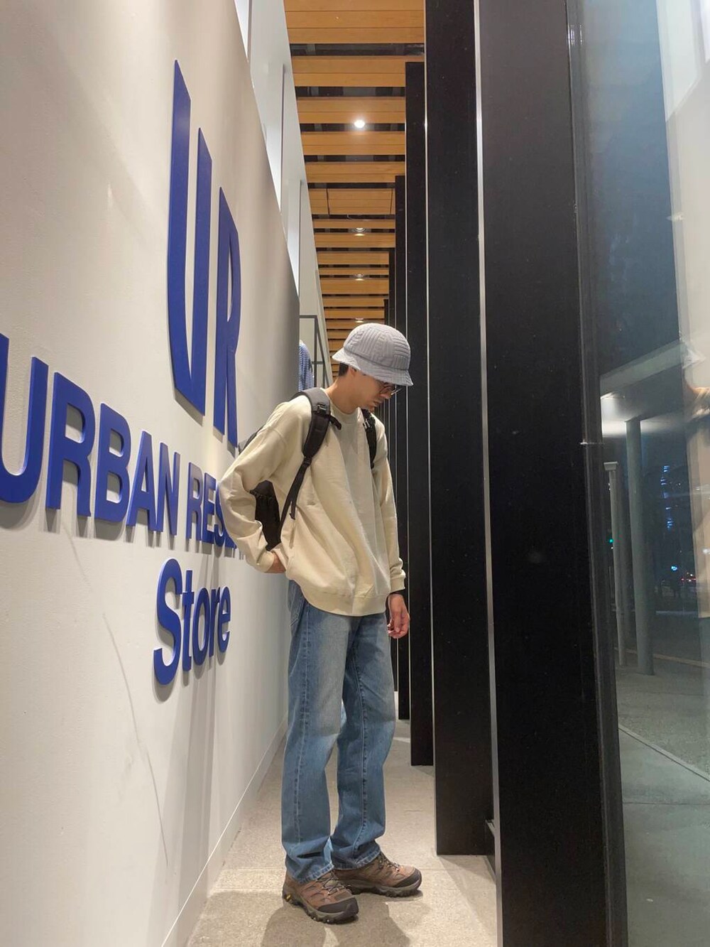 ブラック系のバックパック/リュック、ブルー系のデニムパンツ、ブラウン系のスニーカーを着用したメンズの秋コーディネートの3枚目の写真