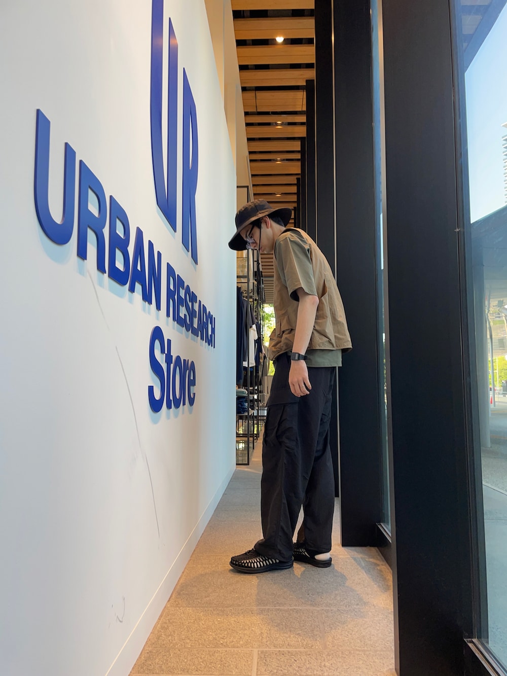 グリーン系のTシャツ/カットソー、ベージュ系のベスト、ブラック系のその他パンツを着用したメンズの春コーディネートの4枚目の写真