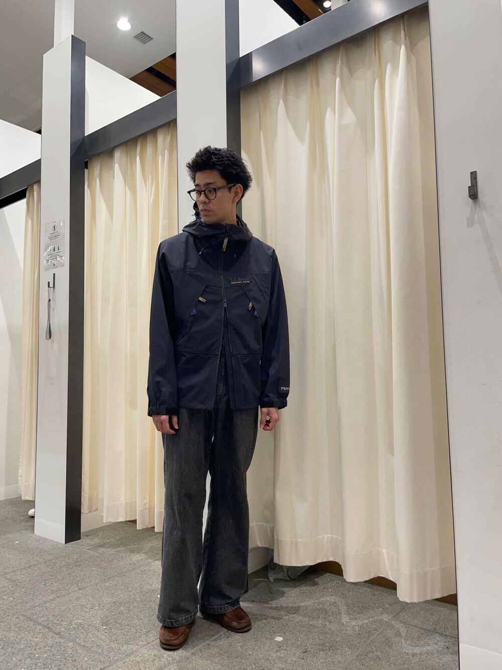 ブラウン系のローファー、ブラック系のデニムパンツ、ブラック系のボストンバッグを着用したメンズの春コーディネートの3枚目の写真