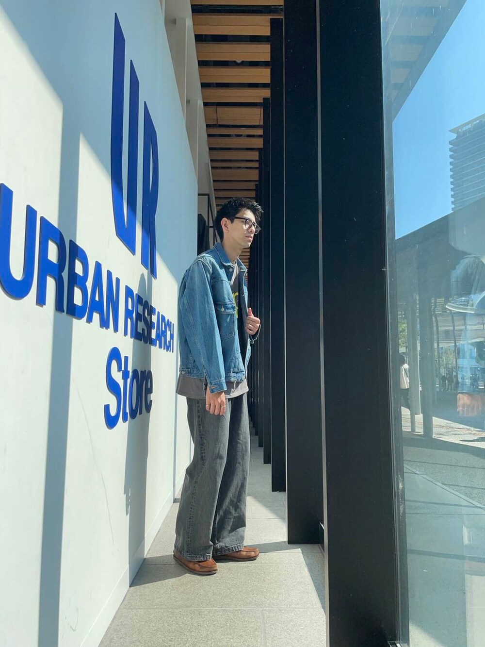 ブルー系のデニムジャケット、グレー系のTシャツ/カットソーを着用したメンズの夏コーディネートの2枚目の写真