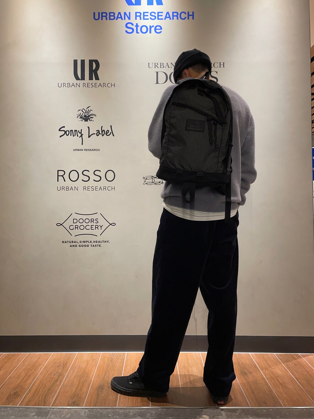 グレー系のニット/セーター、ブラック系のバックパック/リュック、ブルー系のその他パンツを着用したメンズの冬コーディネートの2枚目の写真
